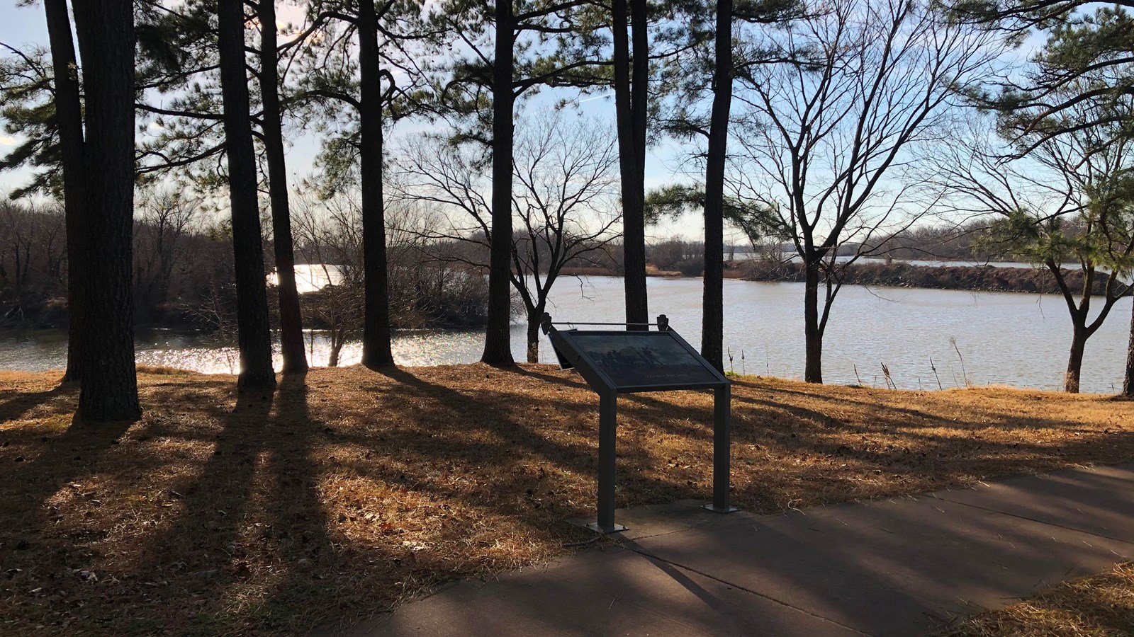 Wayside with pine tress and Poteau river in background in late afternoon sun.