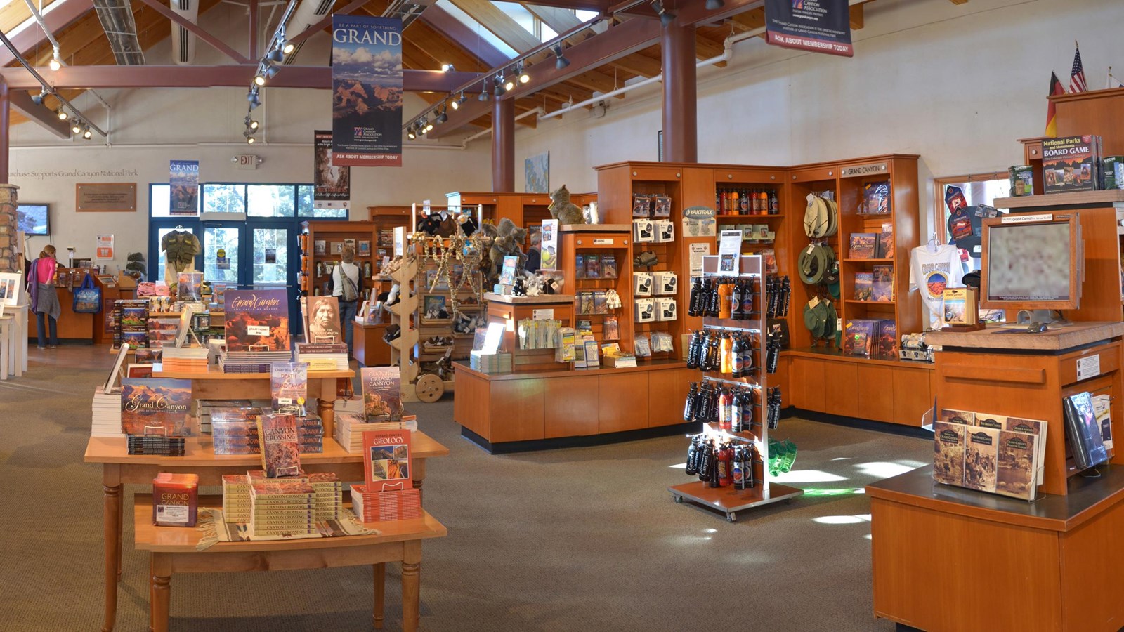 A large indoor space is full of tables and displays featuring books, souvenirs, and gifts.