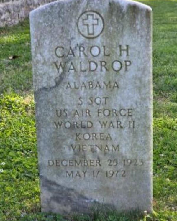 Large marble headstone with a cross on the top belonging to Carol Waldrop. 