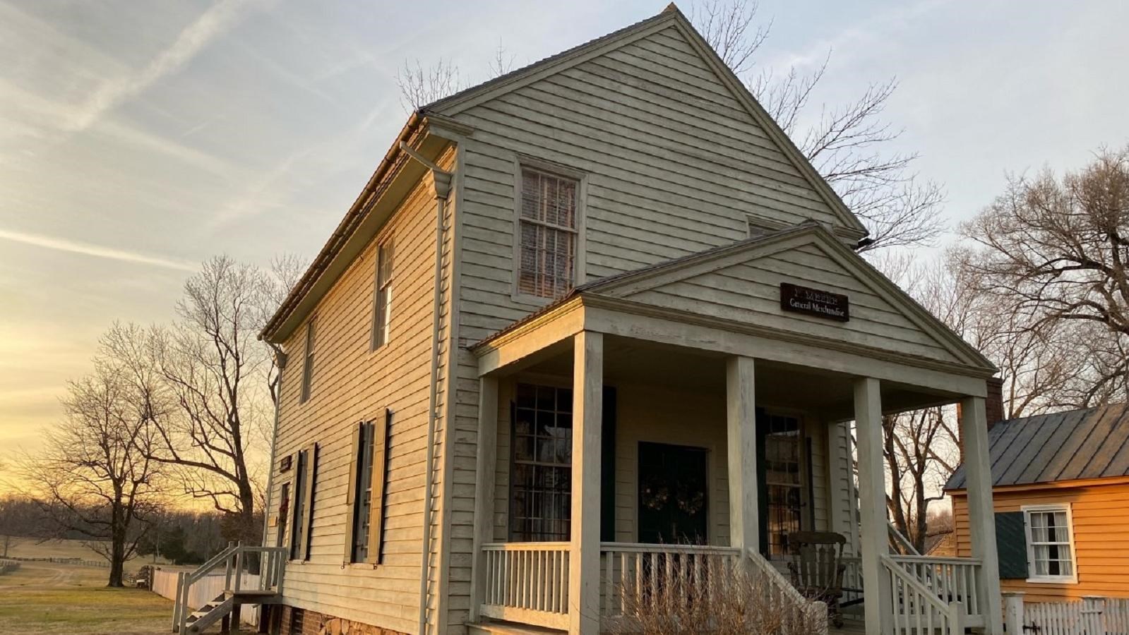 a two-story gray building with a basement and attic. It has a deep pointed rubble fieldstone raised