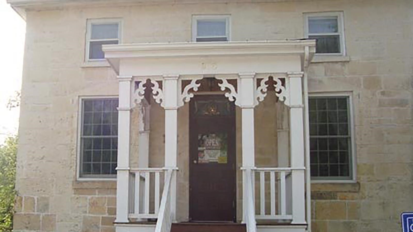 Historic home with an ornate white wooden front porch.