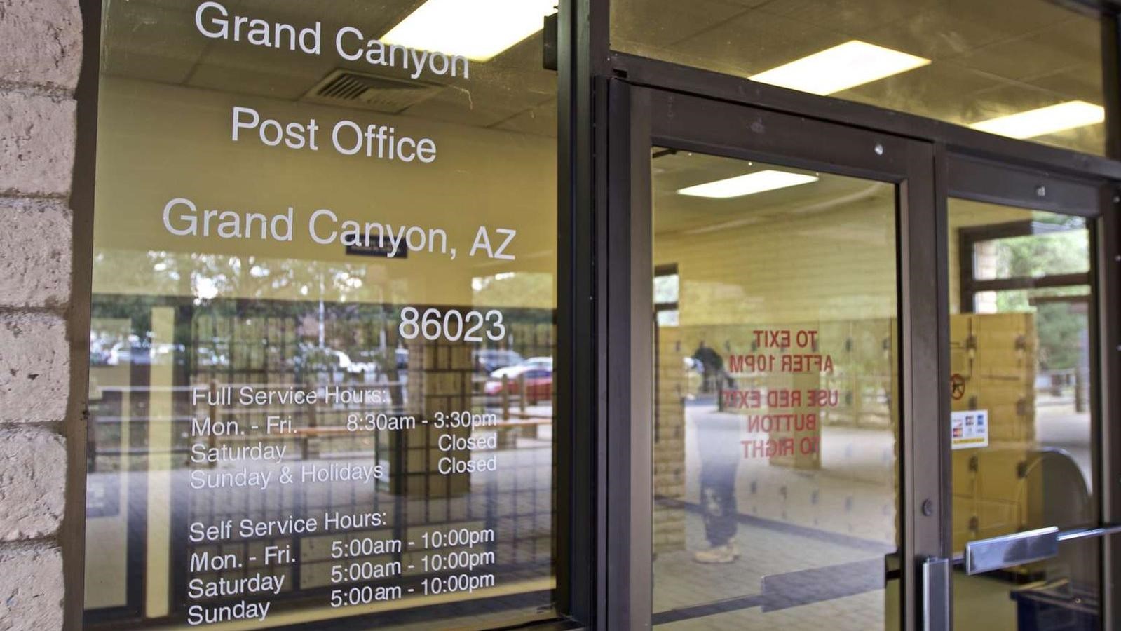 Looking through large glass windows and doors into the lobby and boxes in a post office