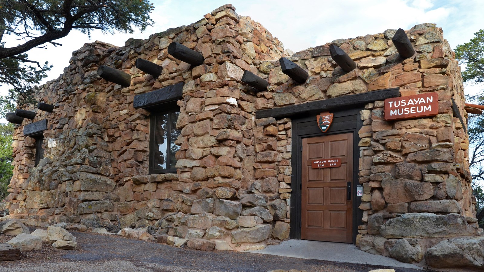 A small building of uncut stone and rough wooden beams reads 