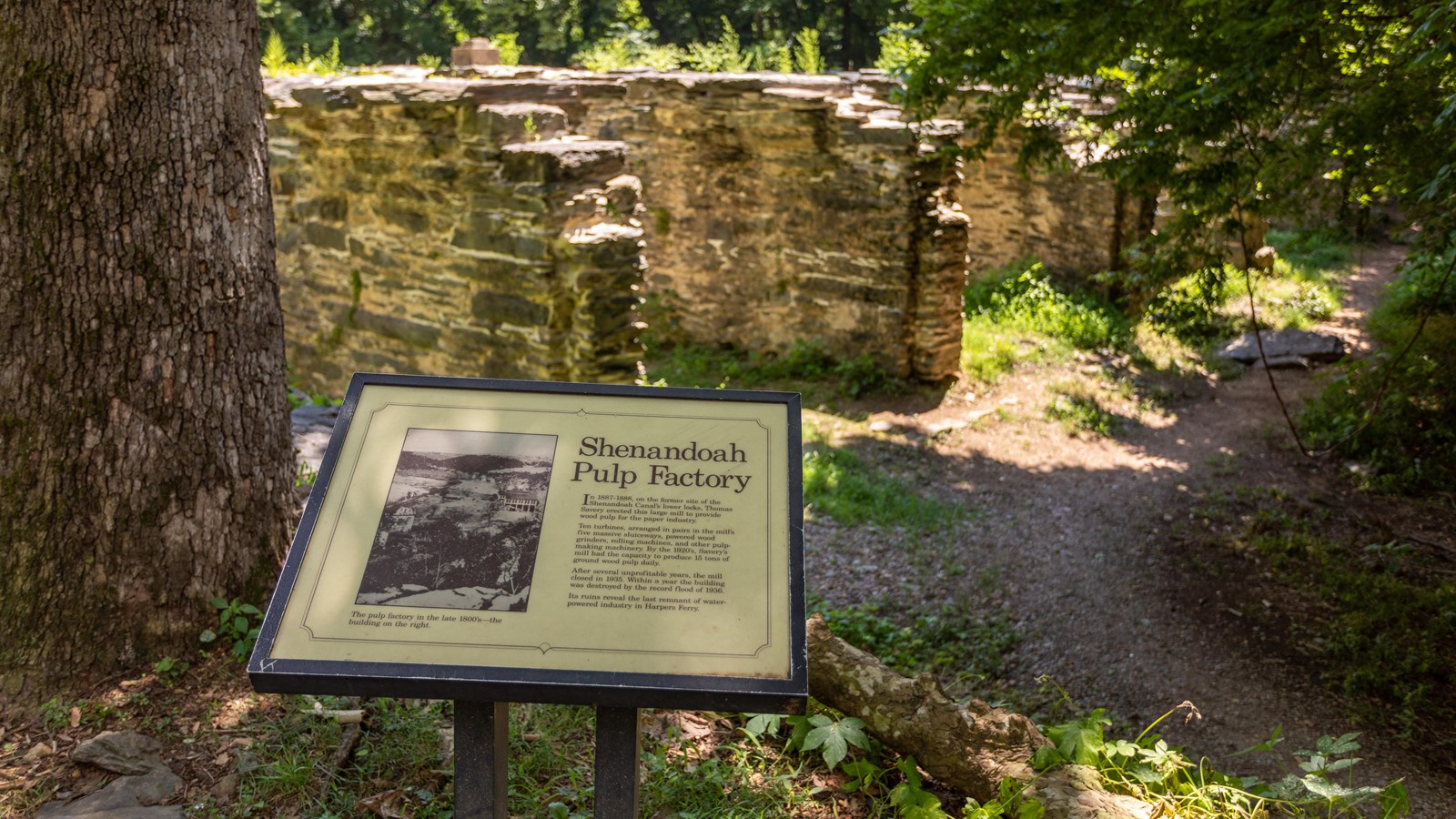 Wayside panel with historic landscape image of buildings from afar. 