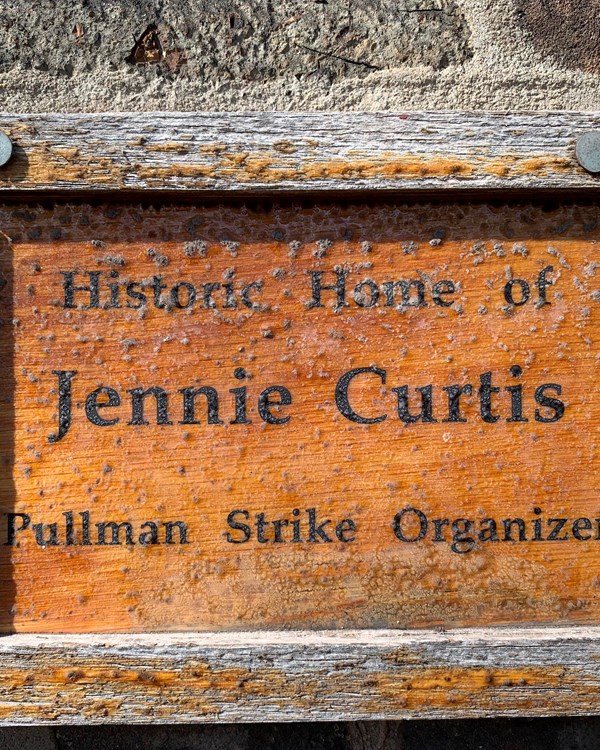 A wooden plaque that says "Historic Home of Jennie Curtis Pullman Strike Organizer".