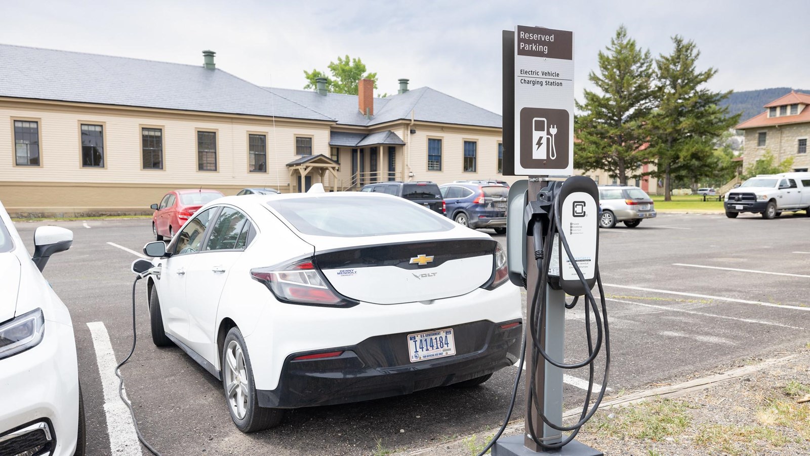 A vehicle charges at an electric vehicle charging station in a parking lot.