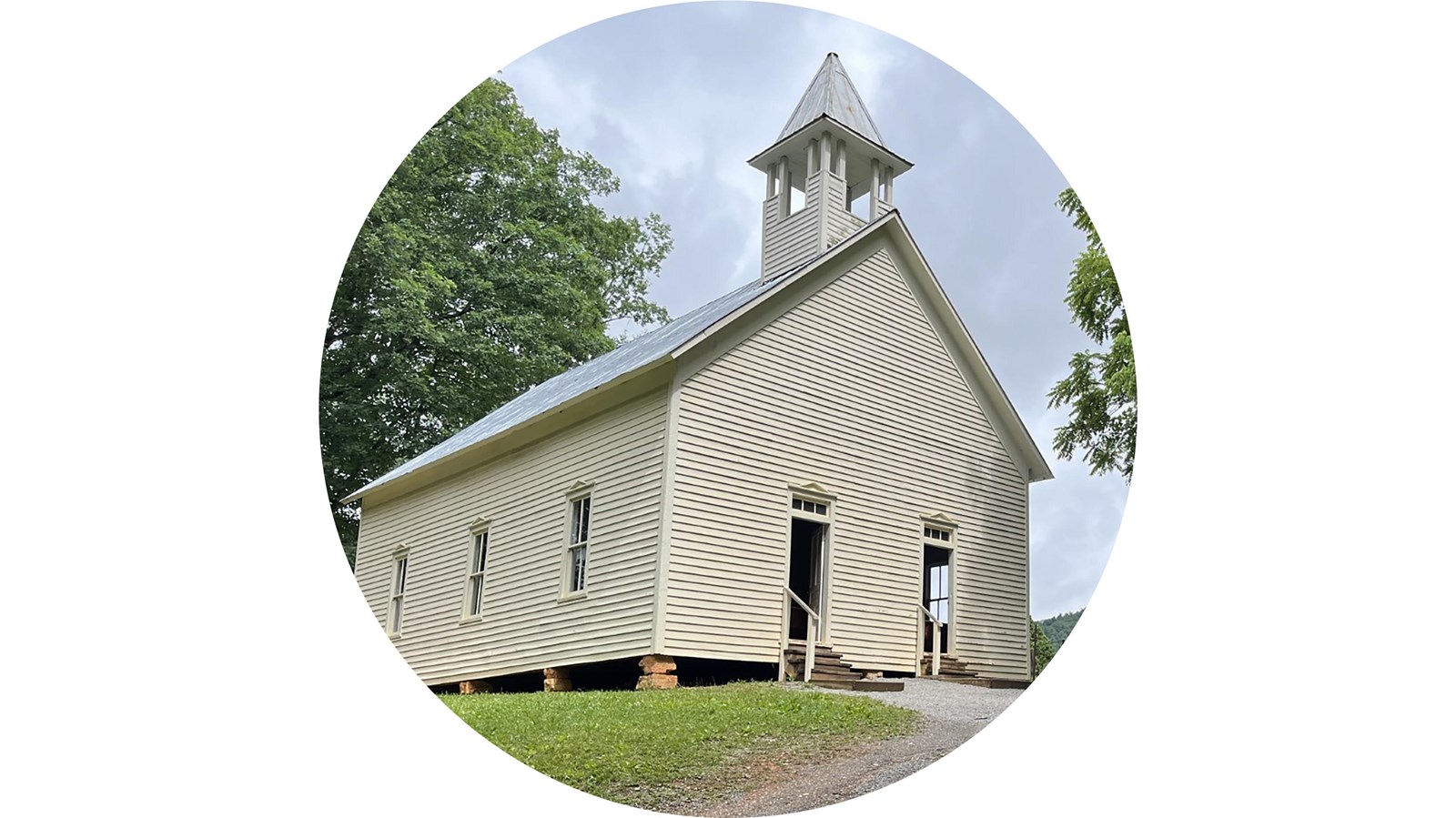 A plain, white, frame church with a fenced cemetery beside it.