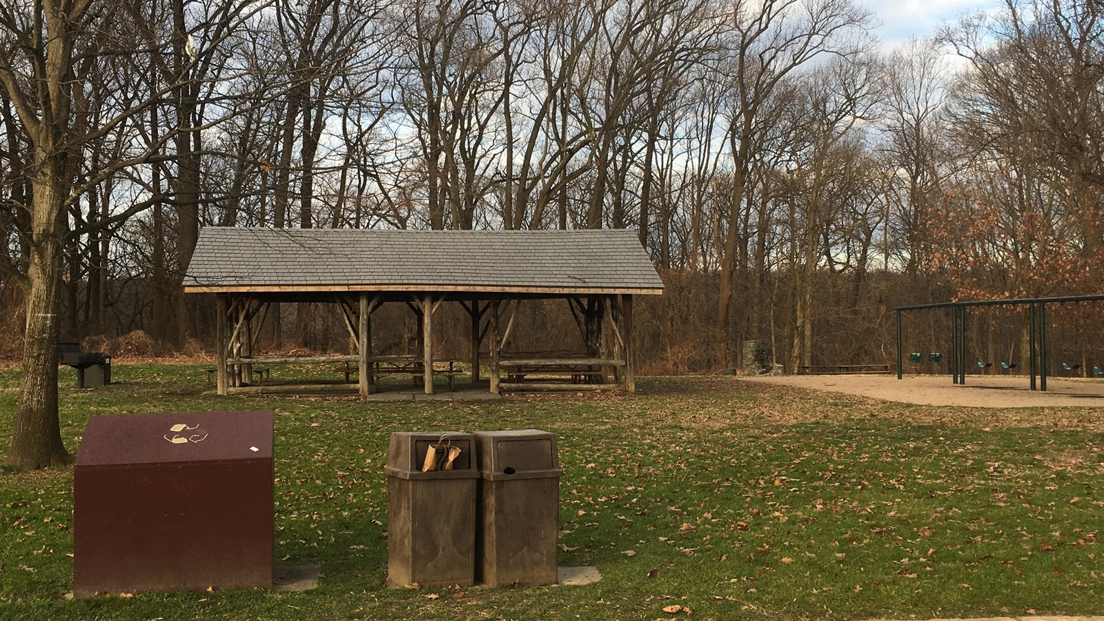 A picnic pavilion, trash cans and playground