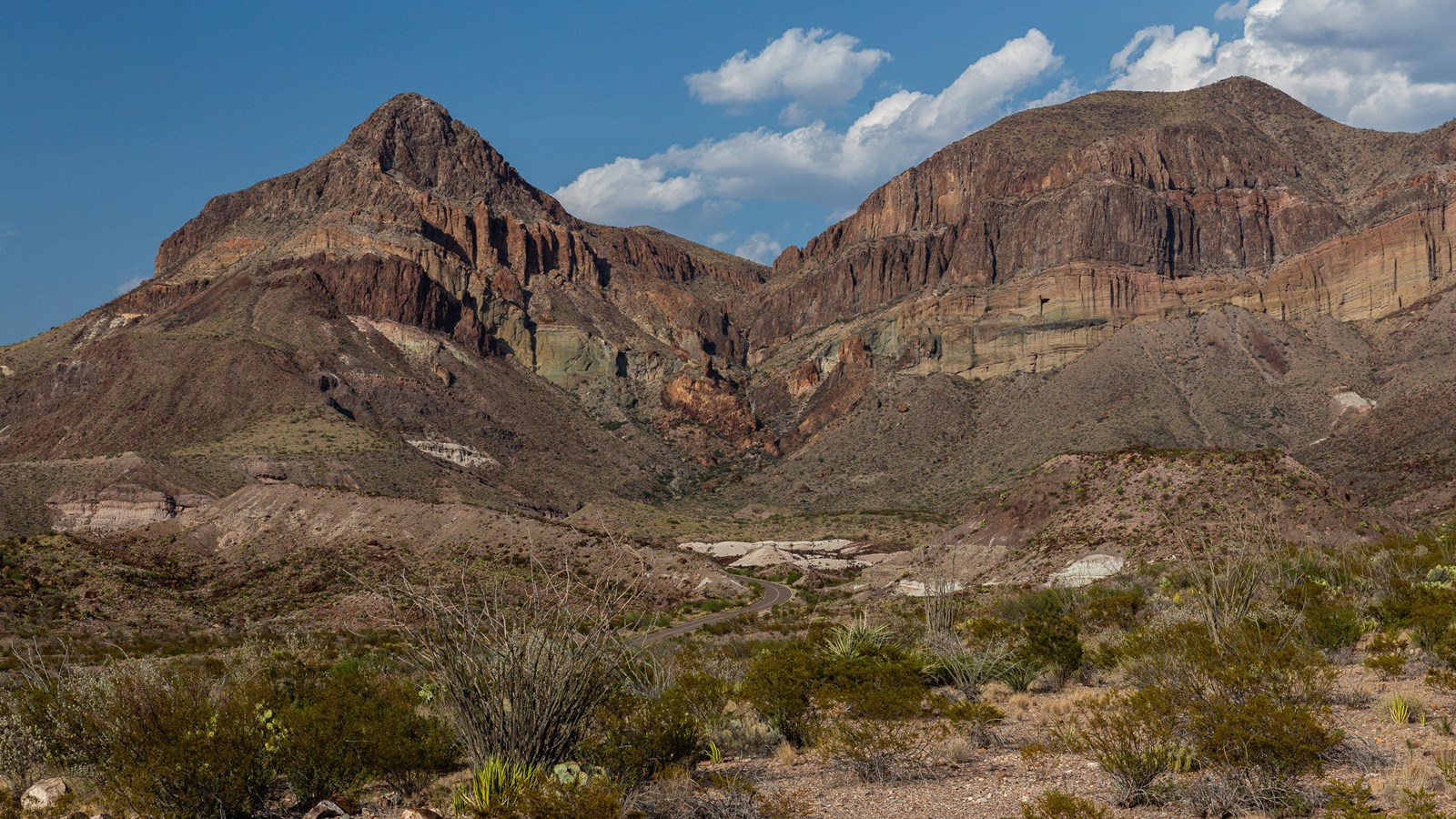 Bands of white, red, and greenish rock strata exposed in the face of Goat Mountain.