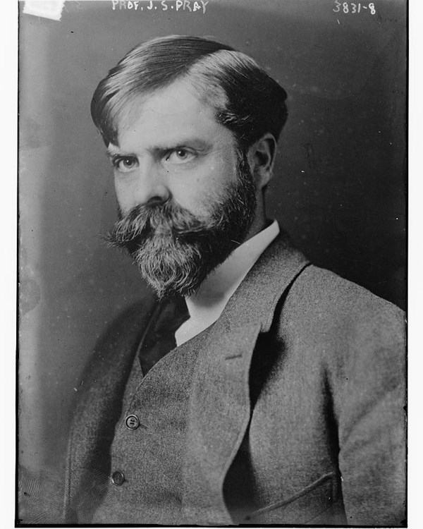 Man in suit, beard and mustache poses for picture