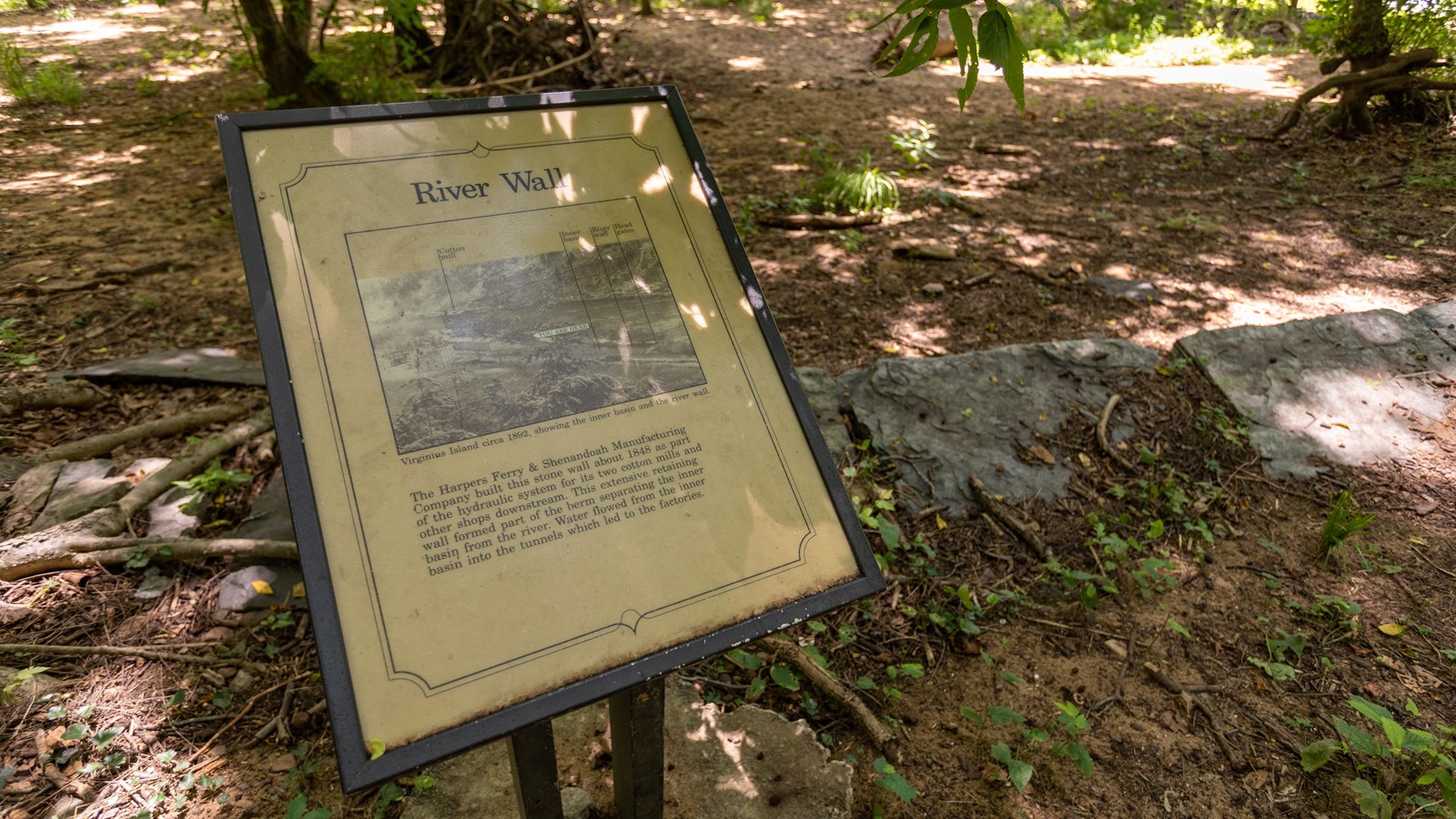 A small exhibit panel indicating the river wall running alongside a river.