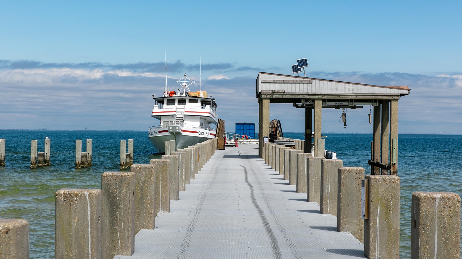 A pier with a ferry docked on the left extends out over the water.