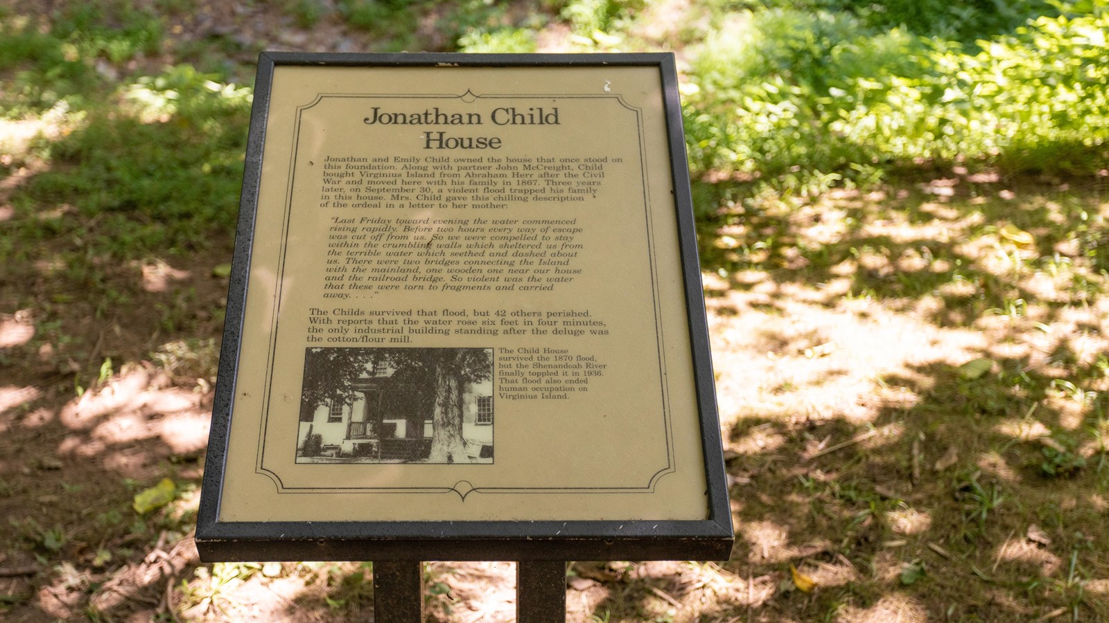 Small information panel with a historic image of a house framed by a large tree.