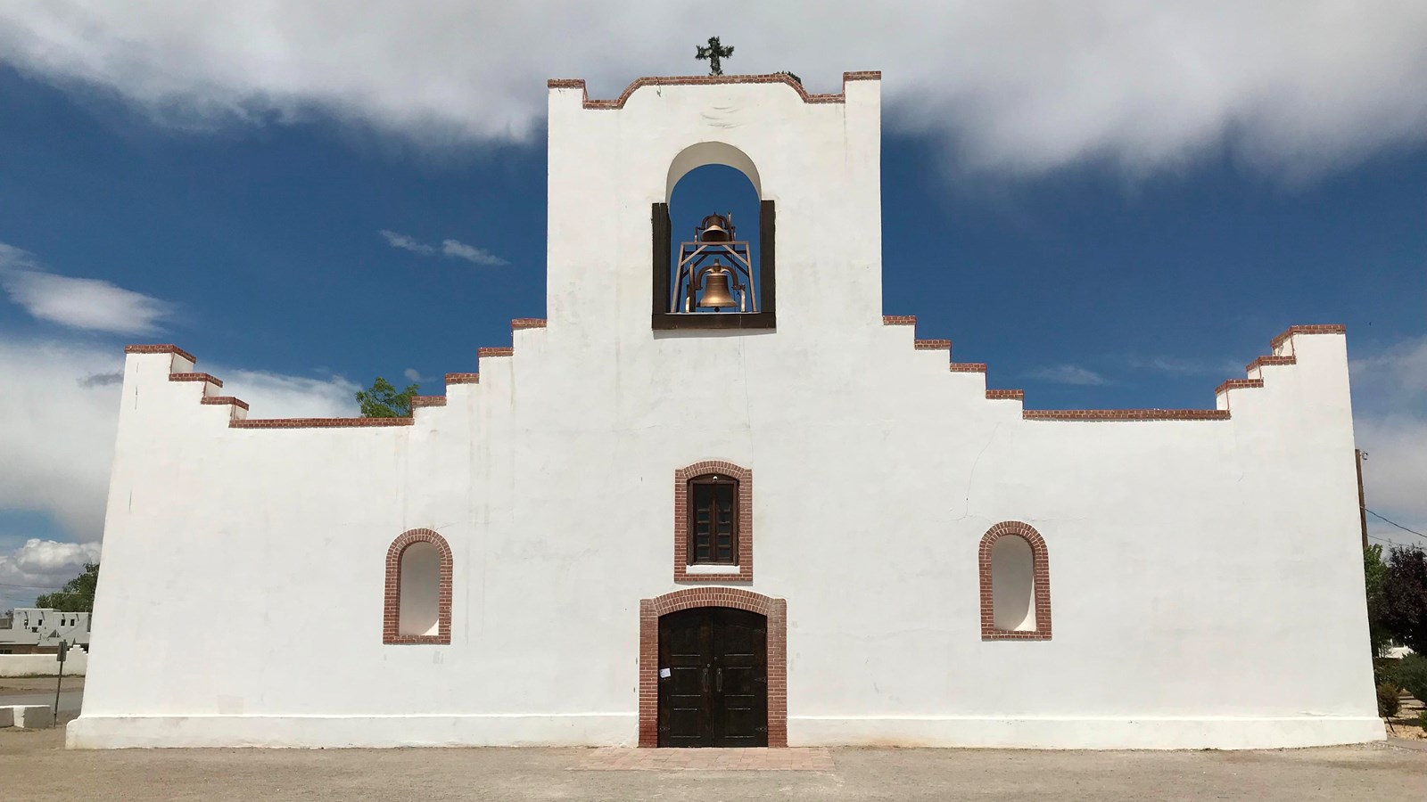 A white stucco mission with a single bell tower.