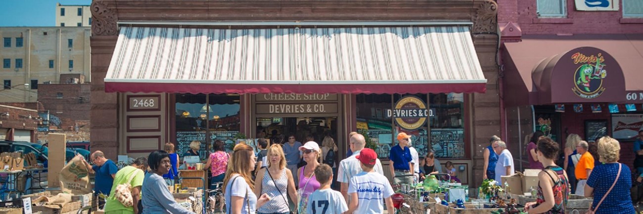 Photo of people outside row of restaurants.