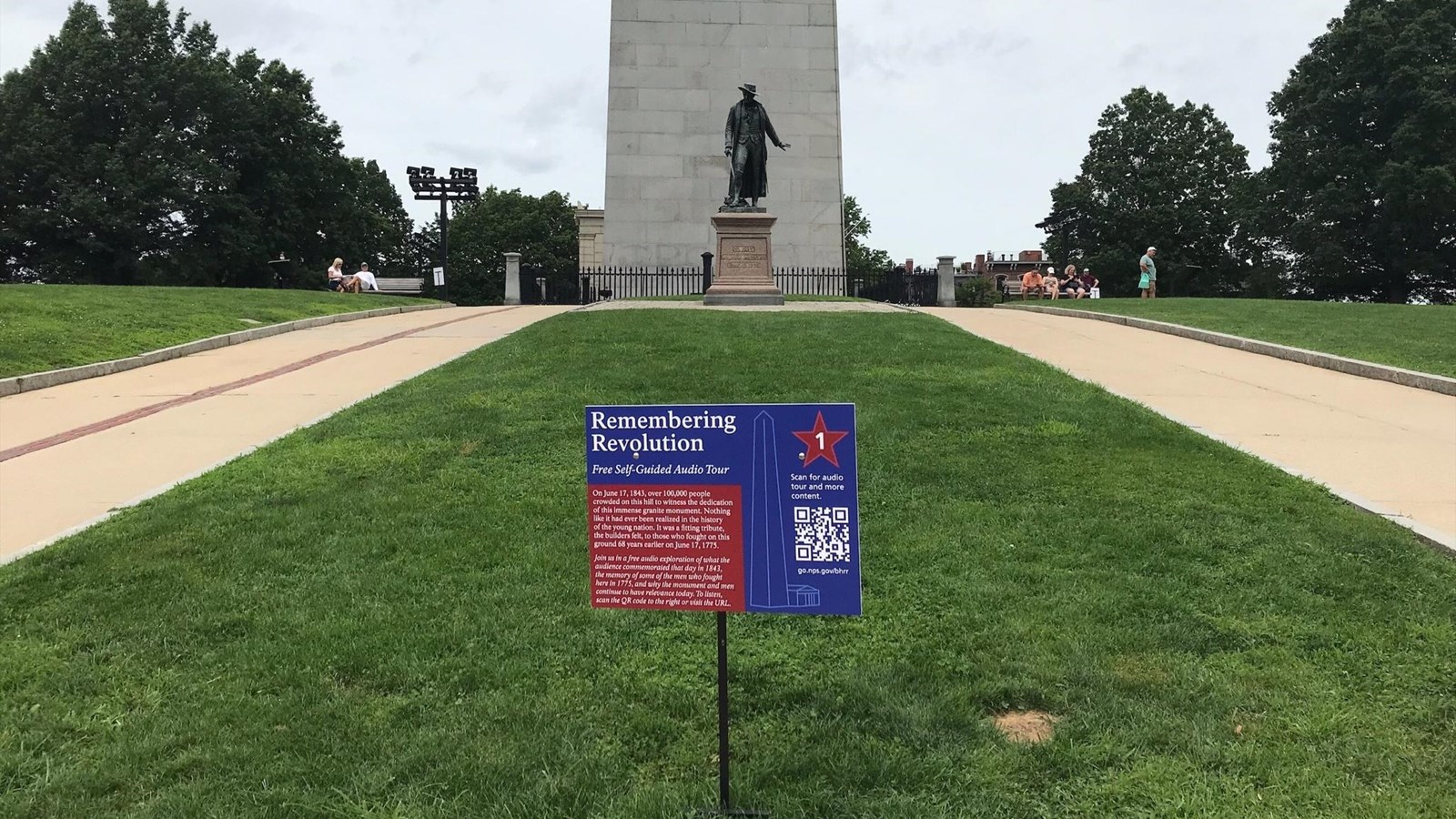blue and red wayside on green lawn in front of Bunker Hill Monument