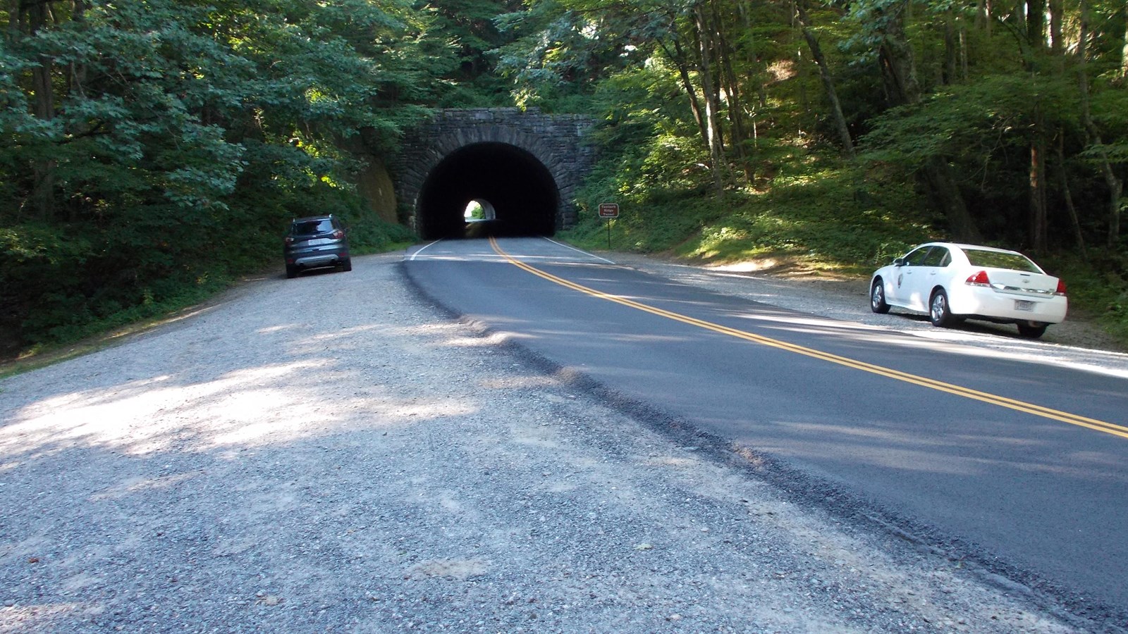 Dirt parking areas on both sides of the Parkway with Tanbark Ridge Tunnel in the background