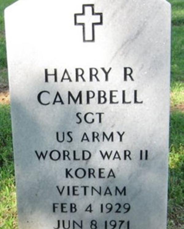 Large marble headstone with a cross at the top belonging to Harry Campbell. 