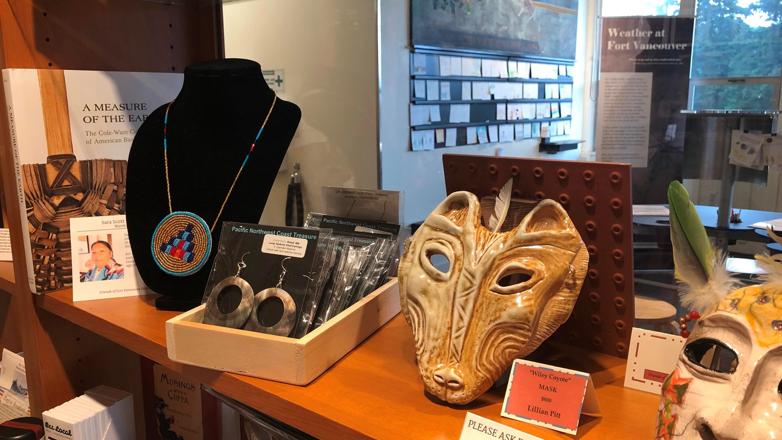 Clay masks and jewelry sit on a shelf.