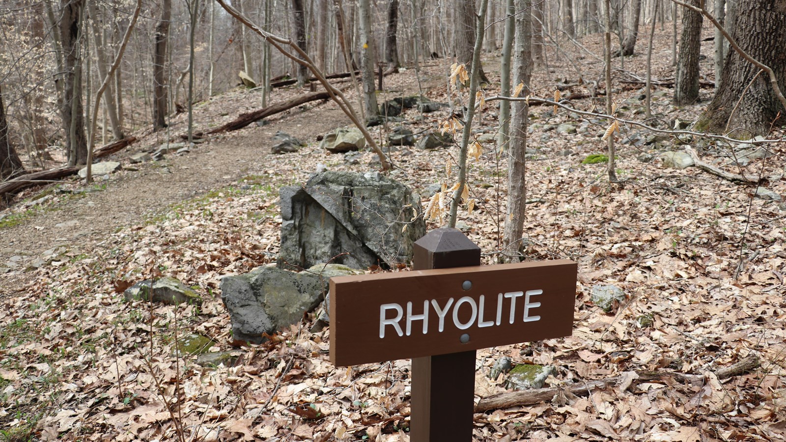 A brown, wooden sign reading