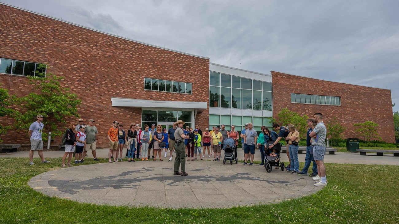 Uniformed NPS ranger holds a program for a large crowd. 