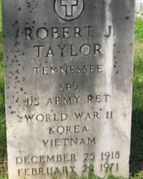 Large marble headstone with a cross at the top belonging to Robert Taylor. 