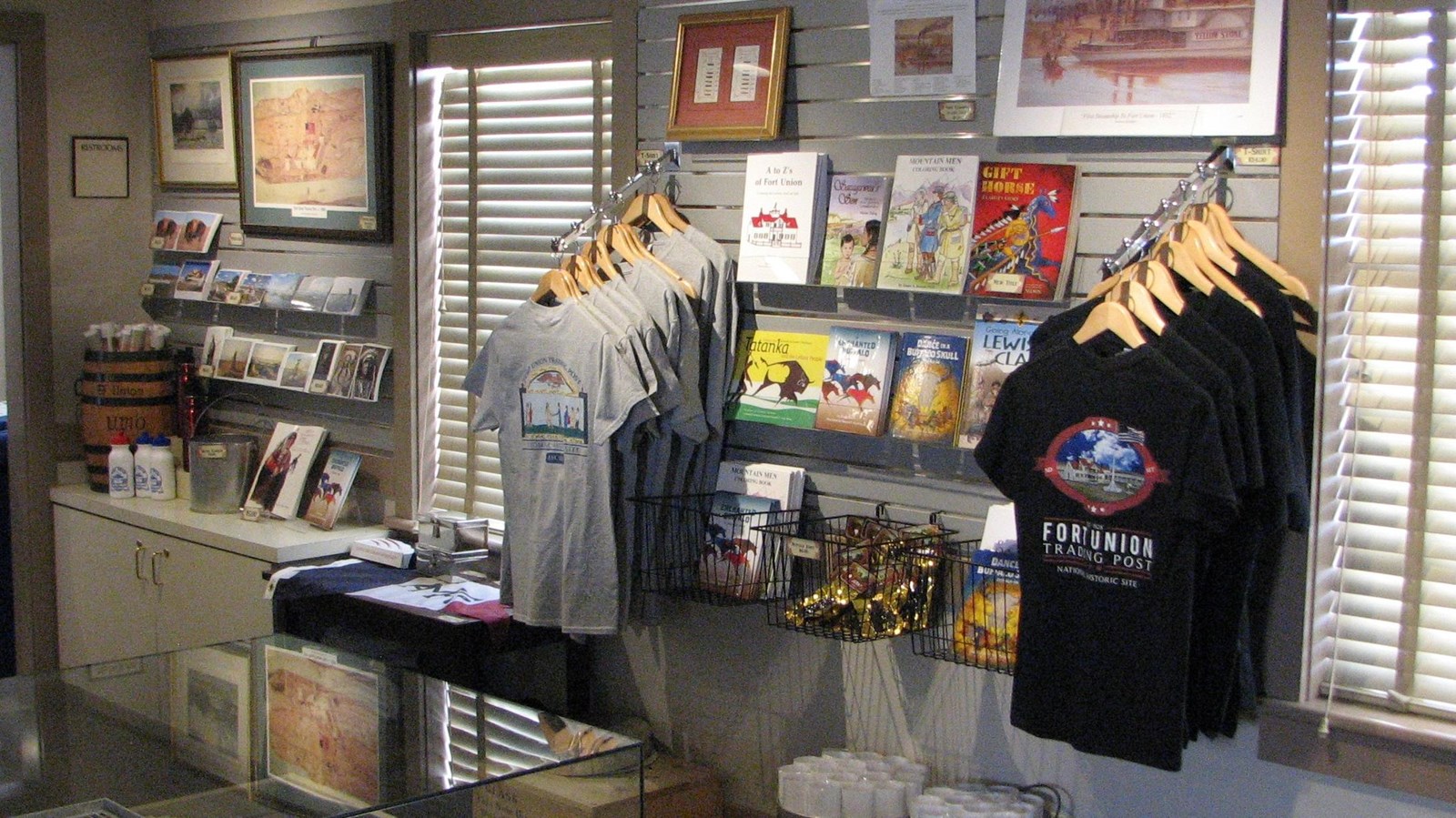 Store wall with sales items including t-shirts, books posters and postcards.