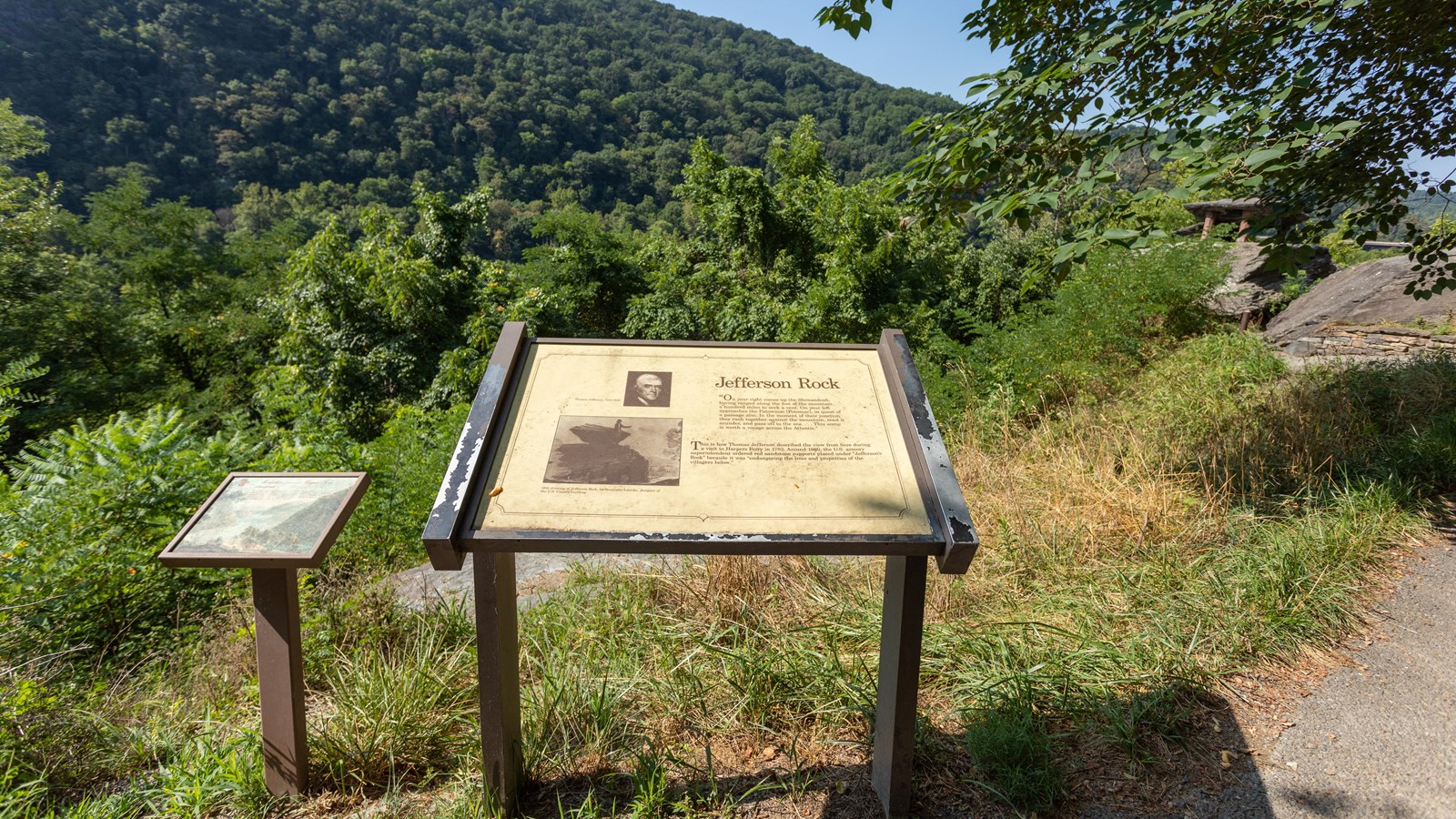 Two signs stand side by side on top of a hill