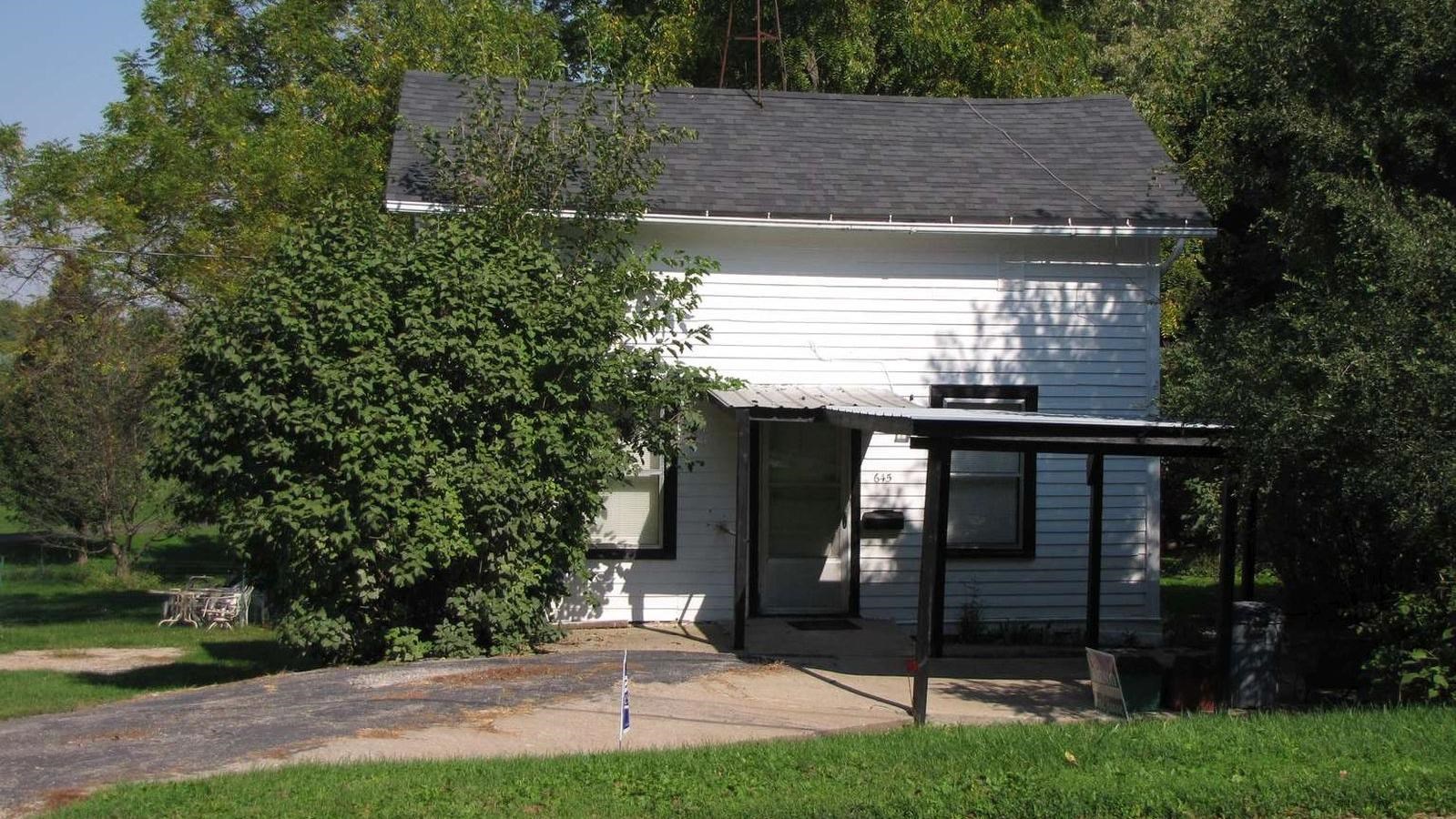 Traveler\'s Rest is a two story, white building white a carport in the front.