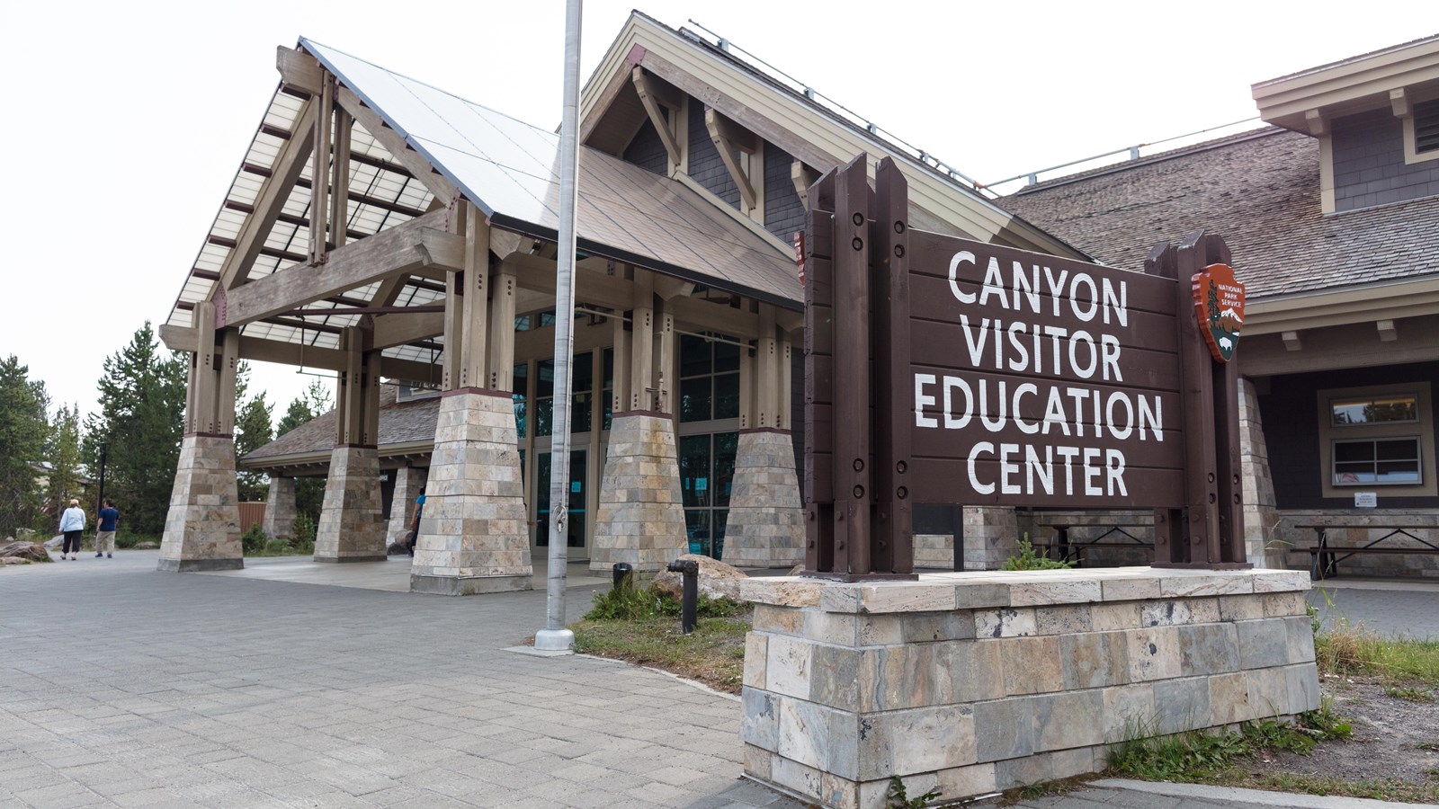 A large timber framed building with a Canyon Visitor Education Center sign in front.