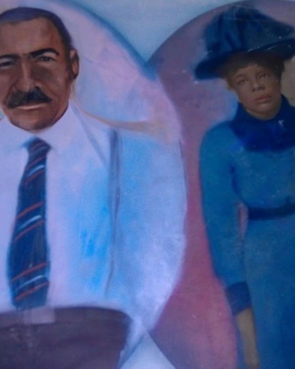 Oval painted portraits of a black man and woman, the man in a suit, the woman in blue dress and hat