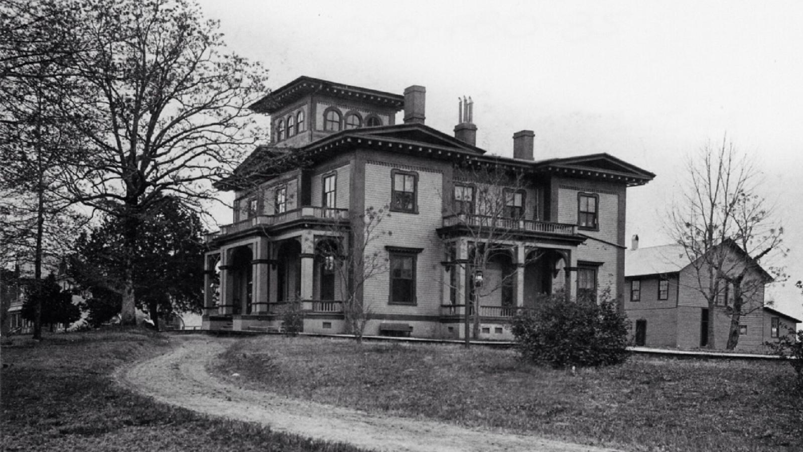 Black and white photo of a large mansion. 