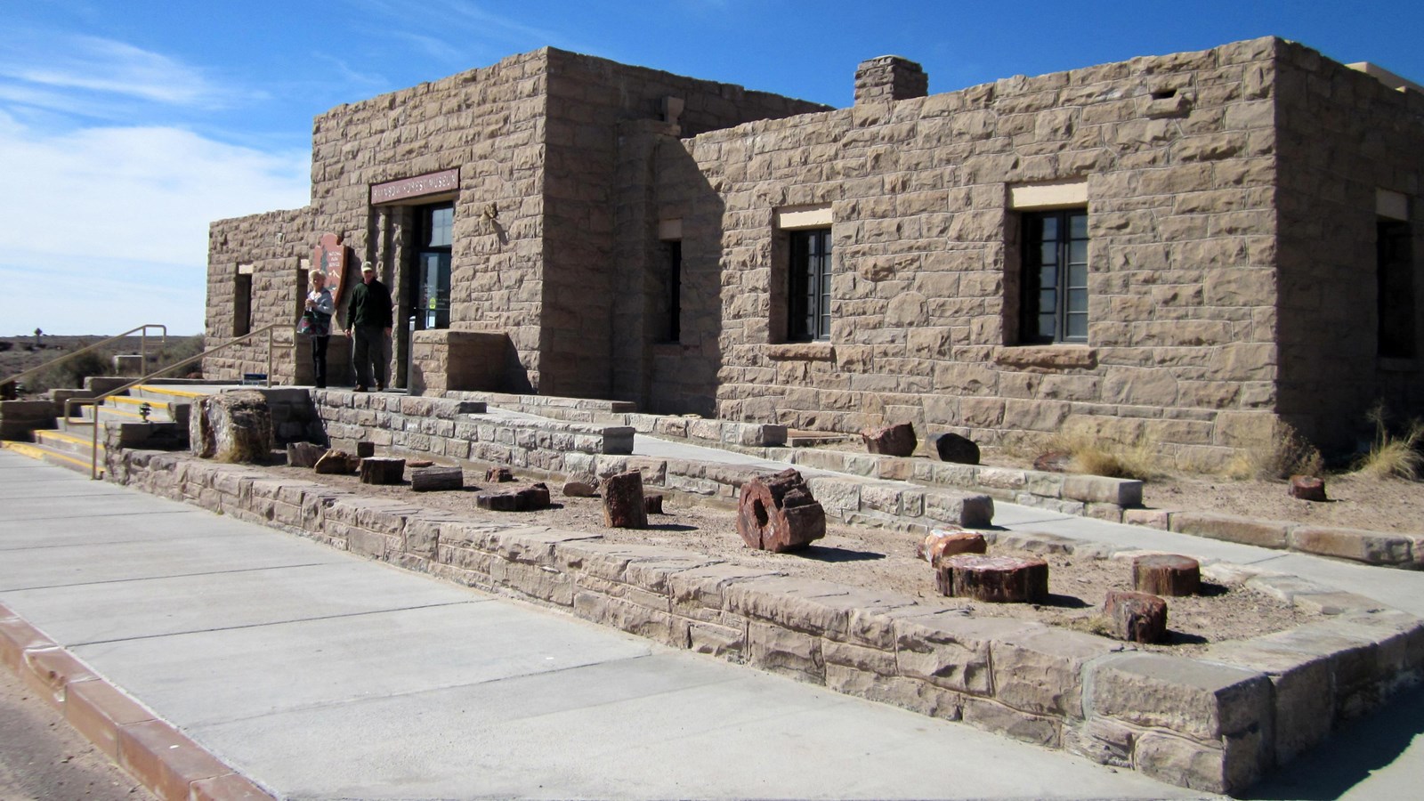 Sandstone masonry building against a blue sky.
