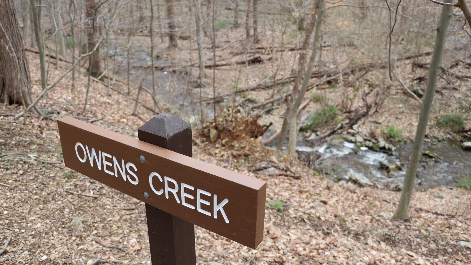 A brown wooden sign reading