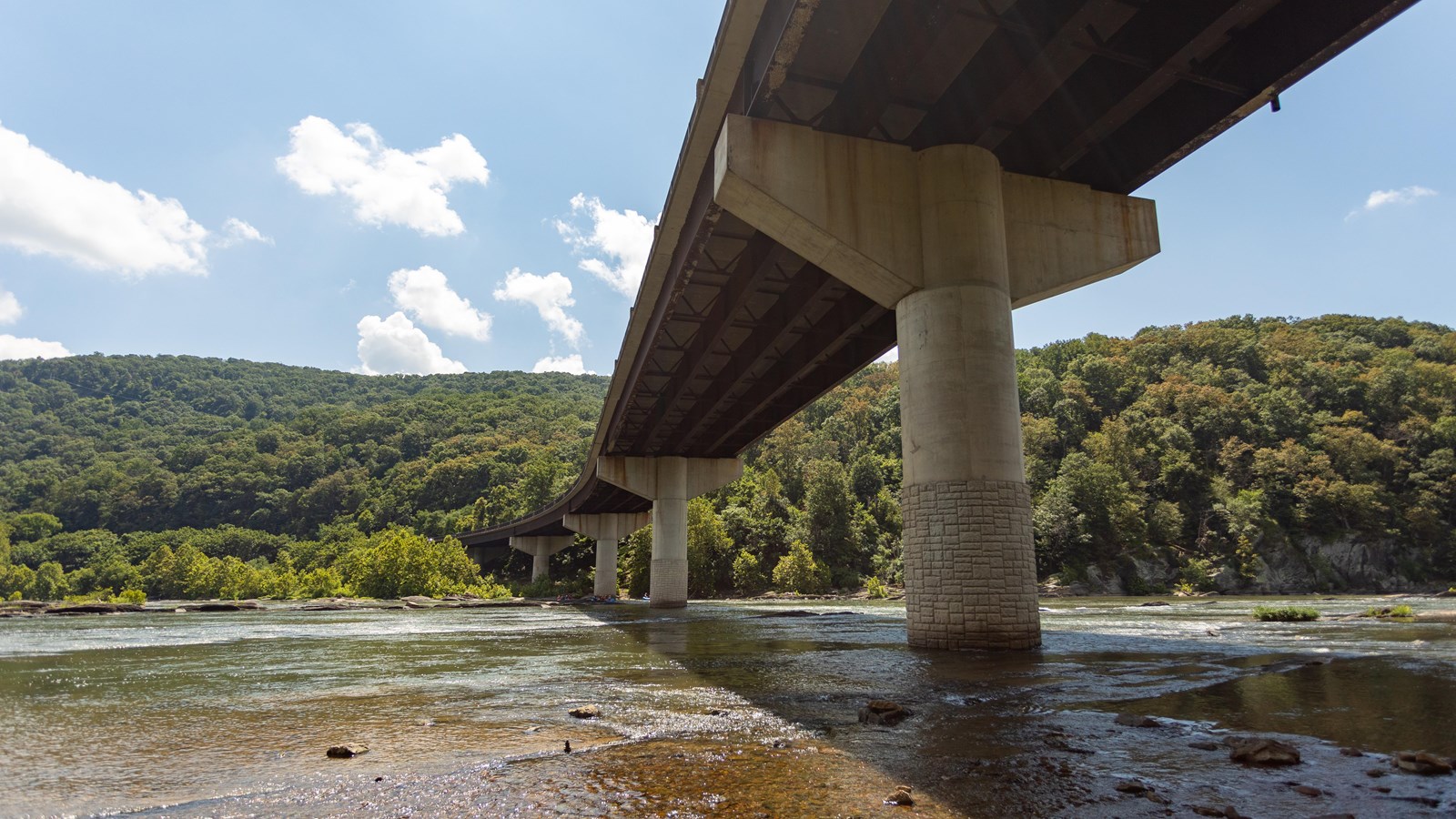 River shoreline with a bridge passing overhead.