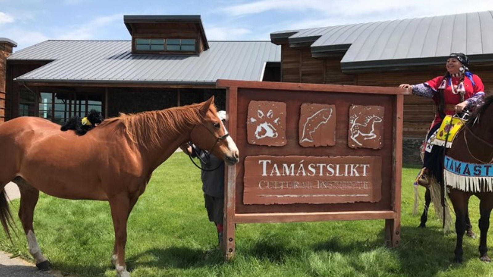 A horse and a person stand next to a sign.