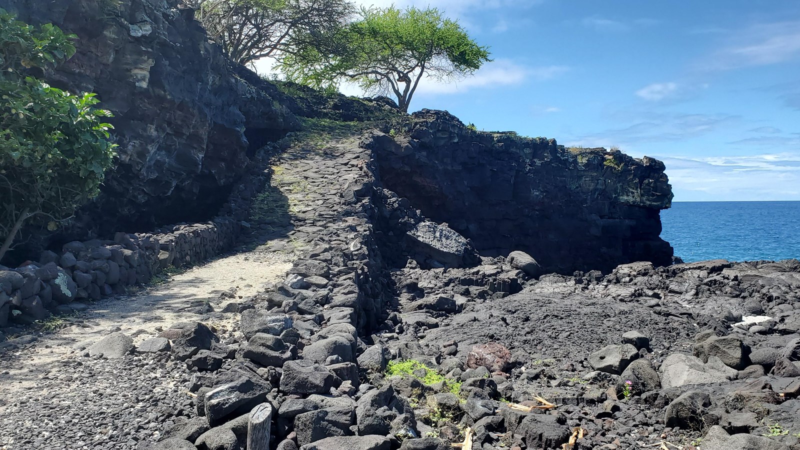 A constructed stone ramp extends up a 20 foot cliff on the ocean\'s edge. 
