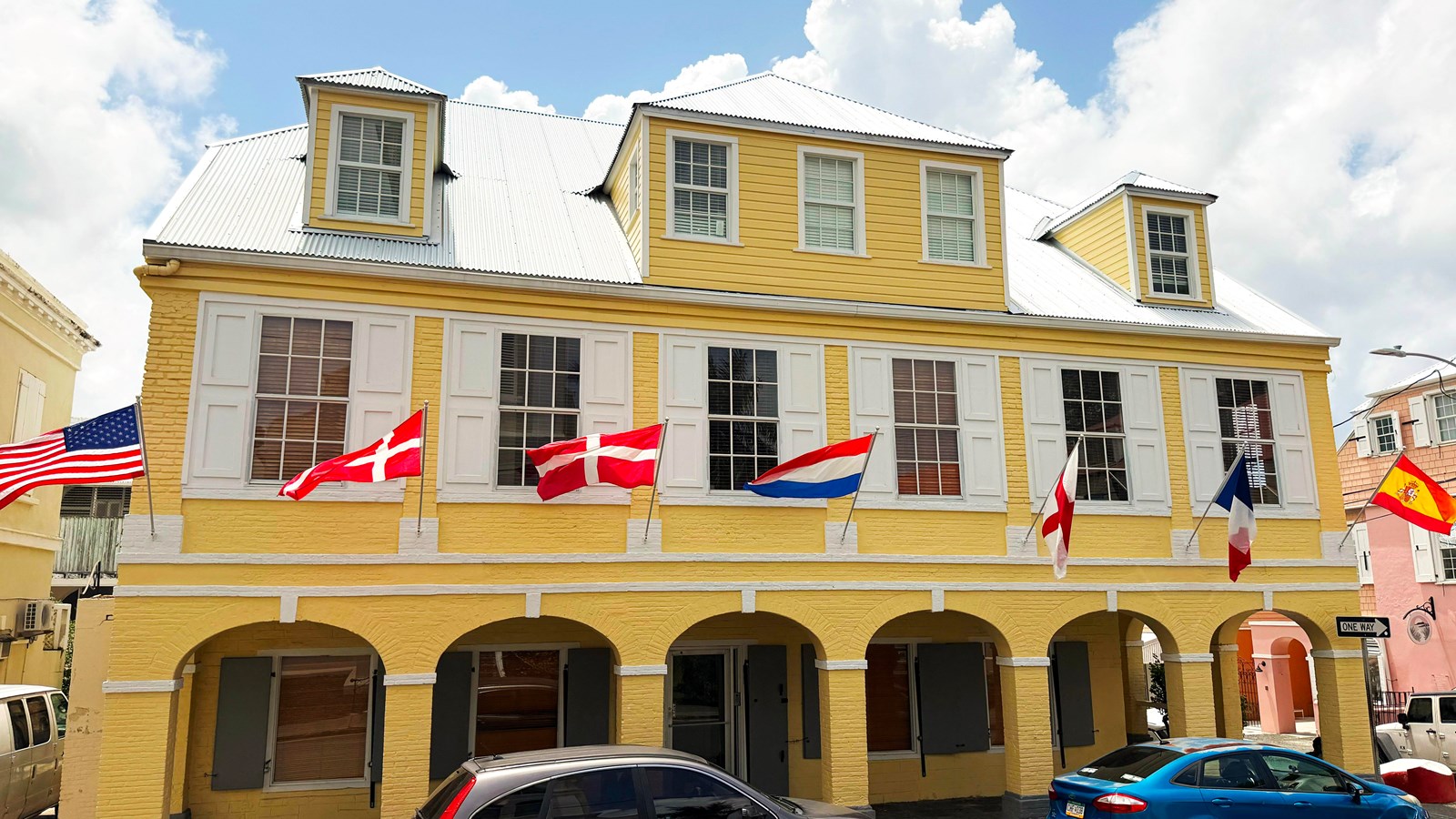 Danish-style building displaying flags of the seven nations that claimed St. Croix over time.