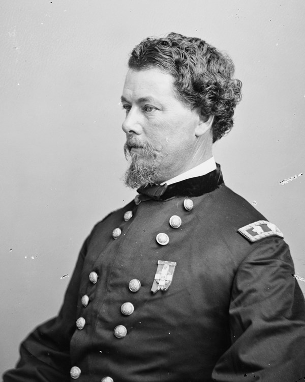 An 1800s seated half-portrait photo shows a bearded man in an army uniform.