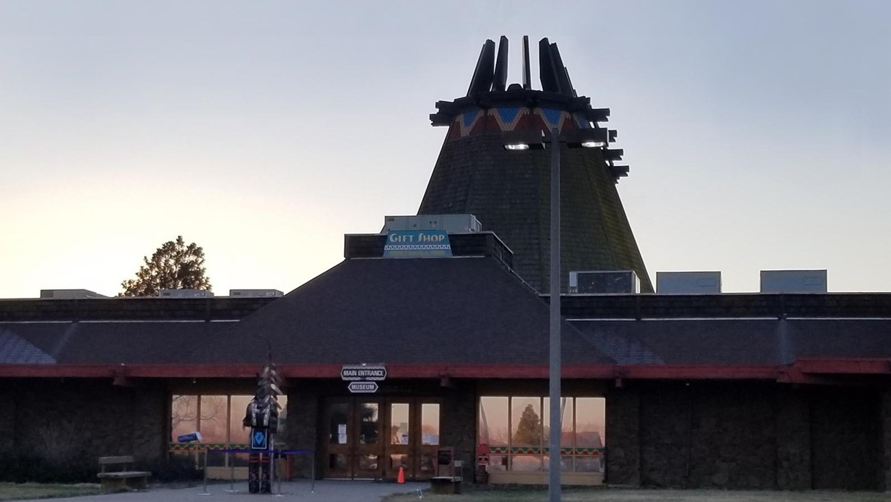 Color photo of a building that resembles a traditional Native American teepee, but far larger. 
