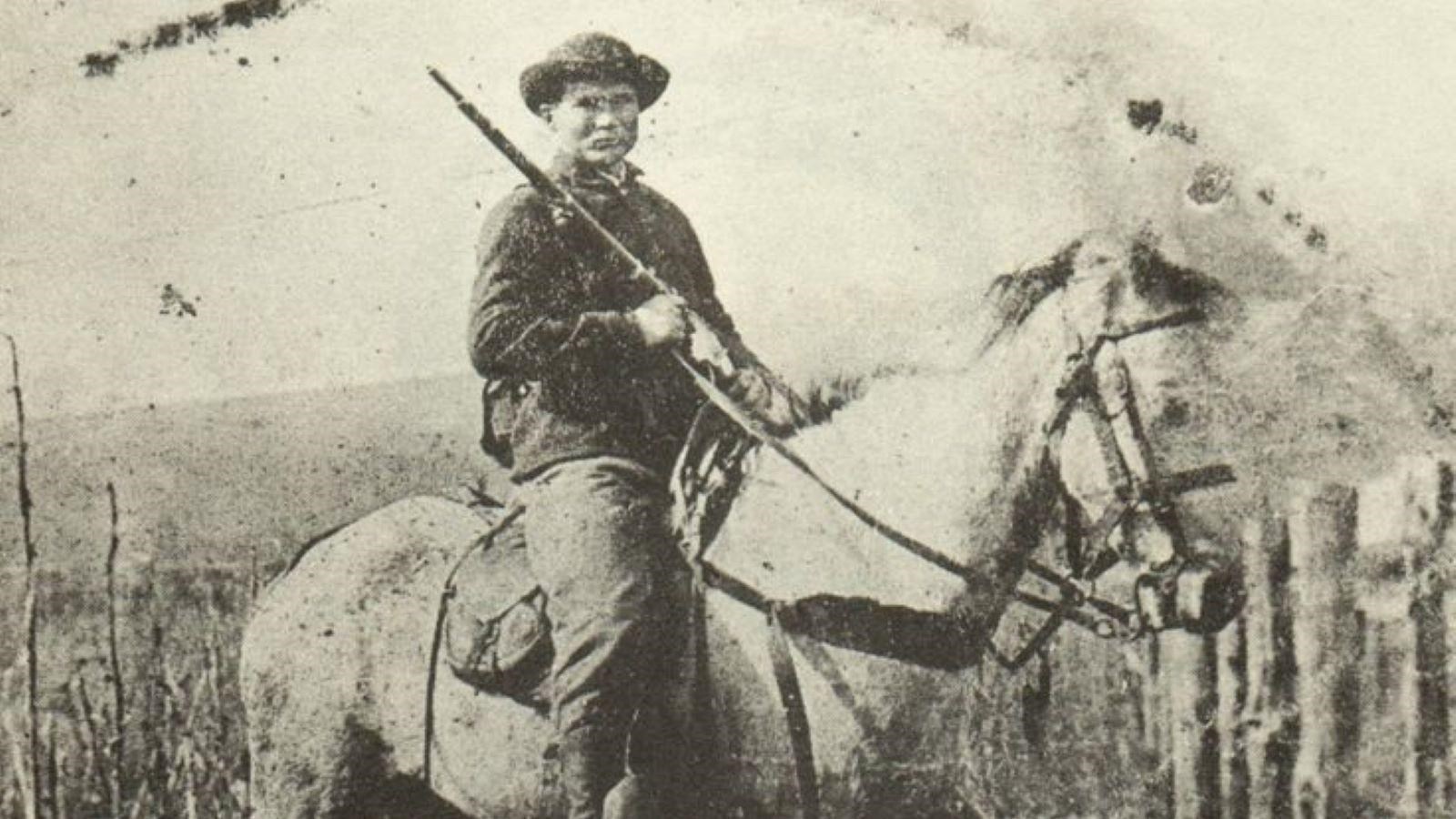 John Munson, a member of Wilder\'s Brigade, sits on a horse and is holding a Spencer rifle