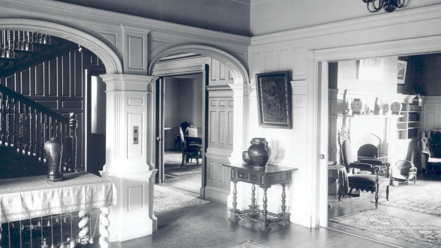 Interior of a house with arches and white walls.