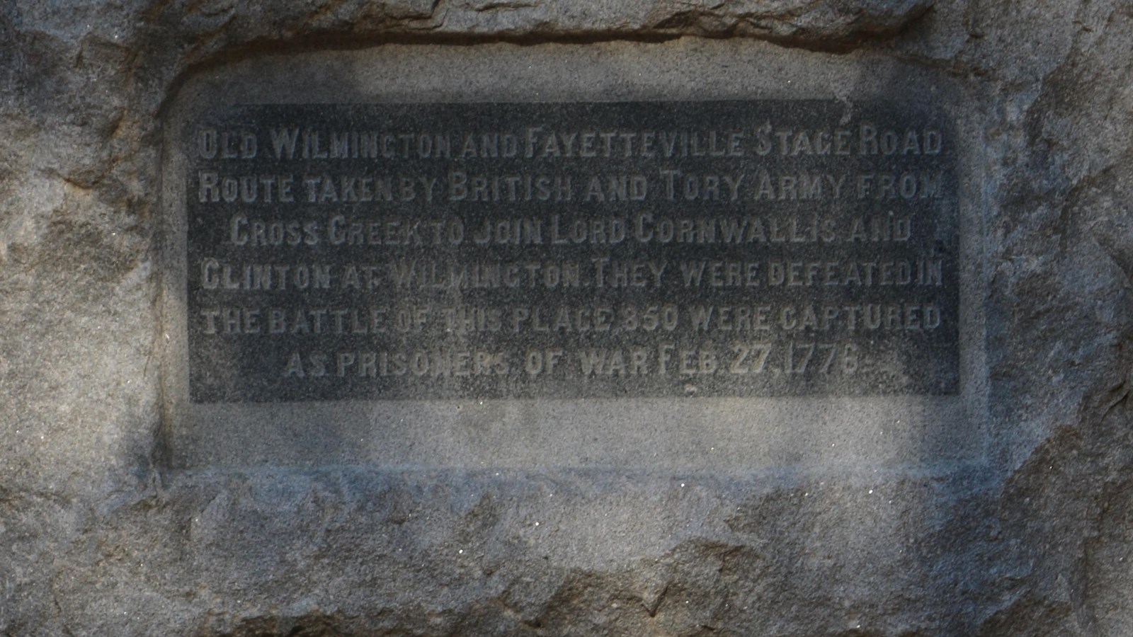 Small Stone Monument (about four feet high) with grassy field around it.