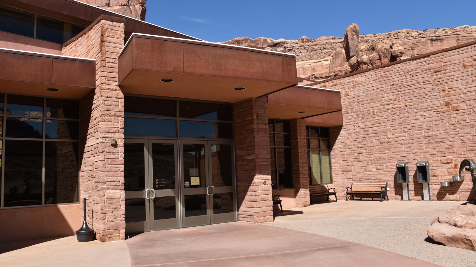 The area includes the entrance to the interior of the Visitor Center and the amenities in the area.