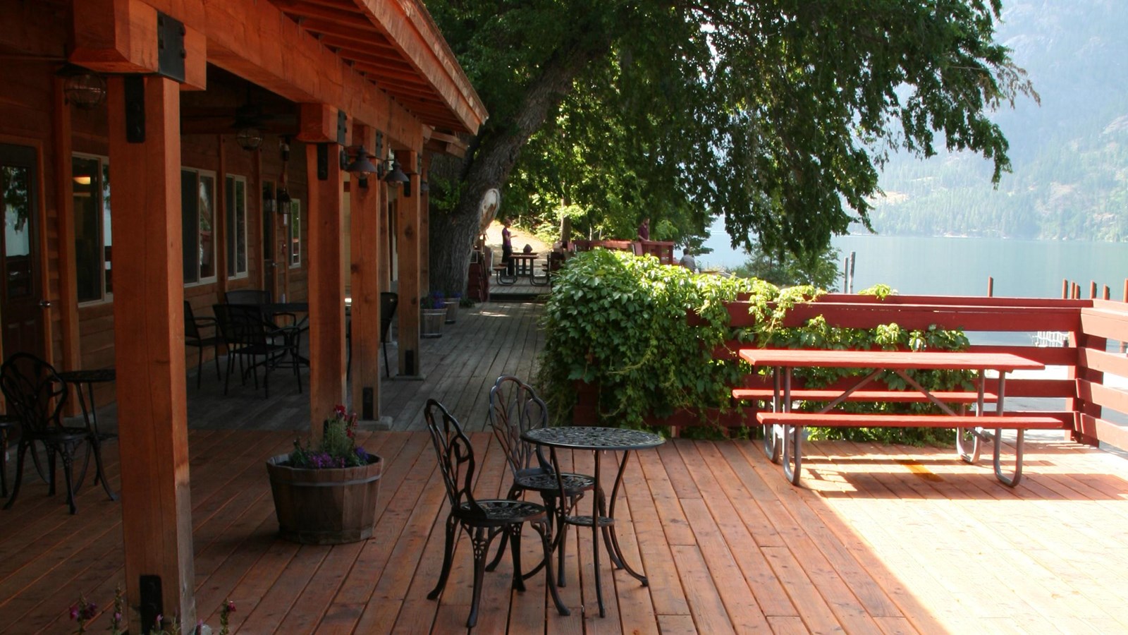 A wooden deck with tables and chairs outside a building.