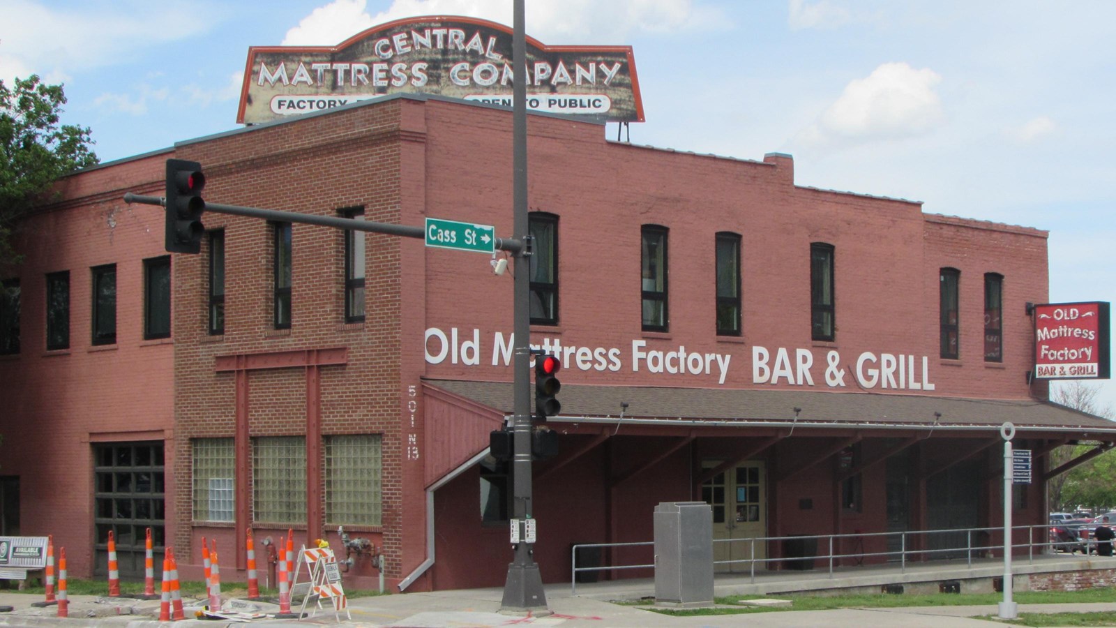 Two-story brick building with covered loading dock on front, rehabilitated for restaurant use.