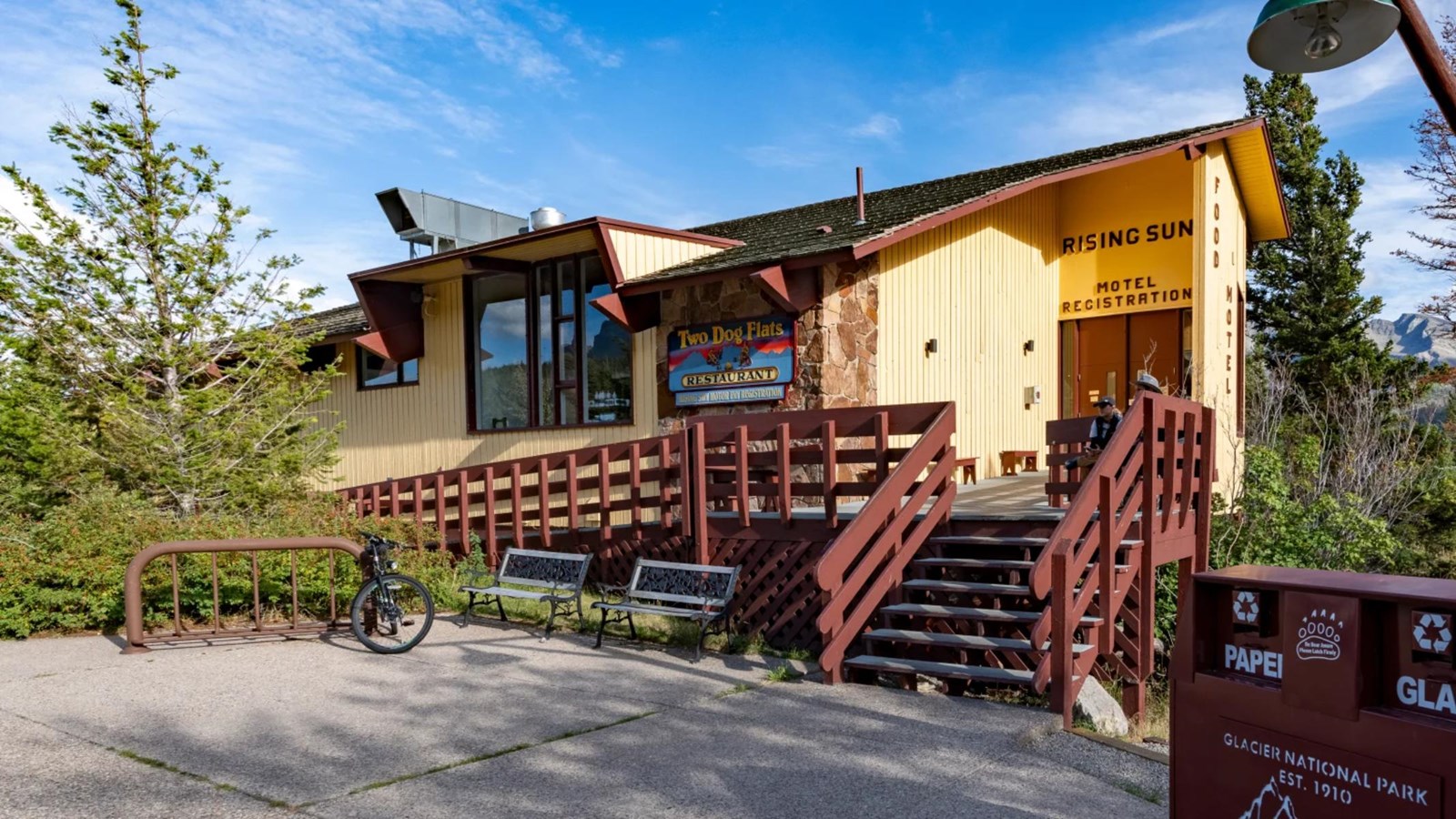 A yellow and stone Mission 66-style motel with brownish-red porch.