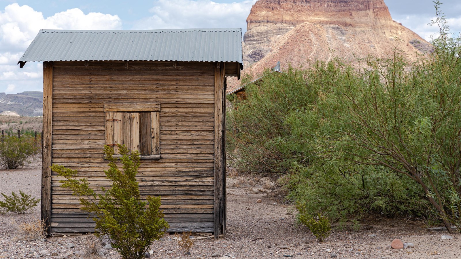A small boarded up wooden structure The area around is Chihuahuan desert.