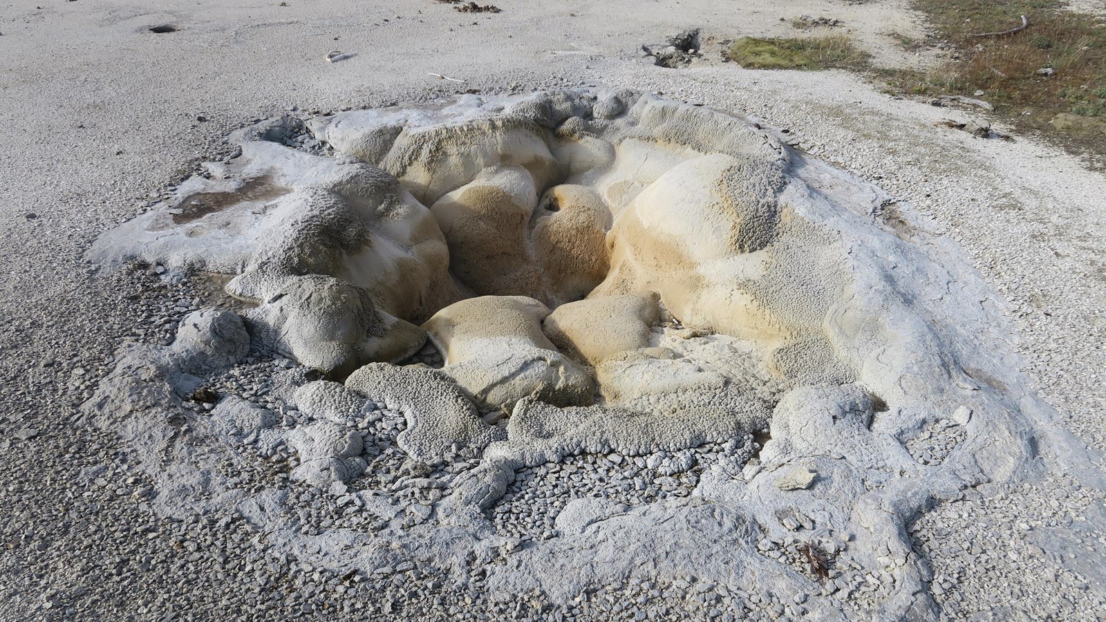 A depression in the sinter from a dry hot spring in a geyser basin.