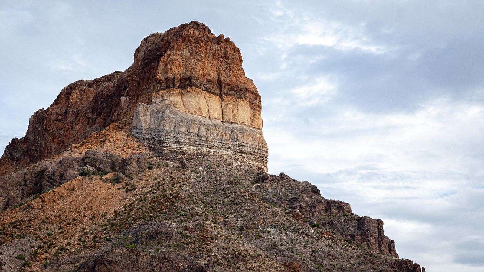 A volcanic vent with banded layers of red, orange, and white pyroclastic deposits.